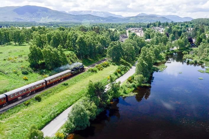 Steam train approaching Boat of Garten Station on the Strathspey Railway
