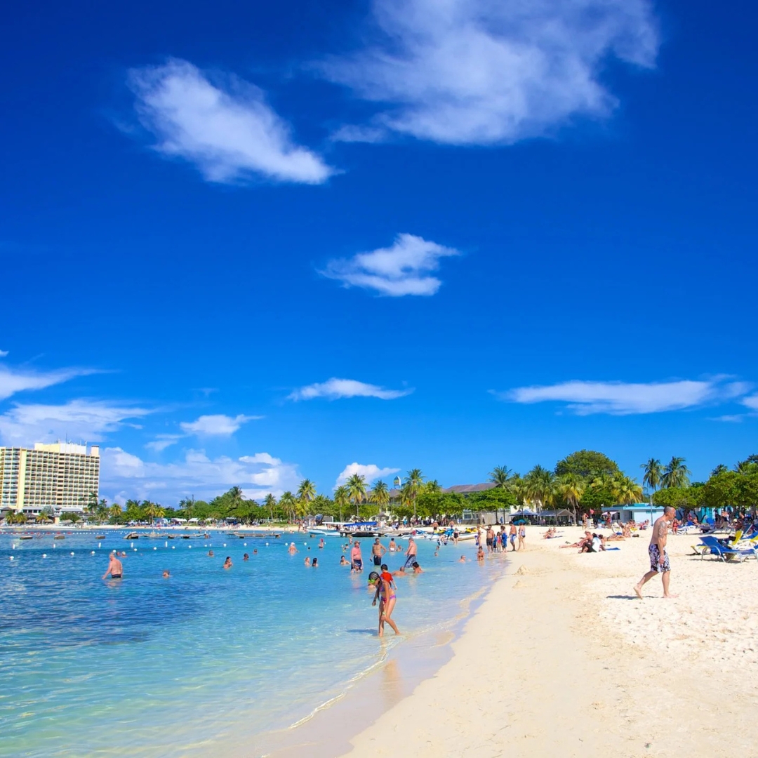 A sunlit tropical beach and clear Caribbean water