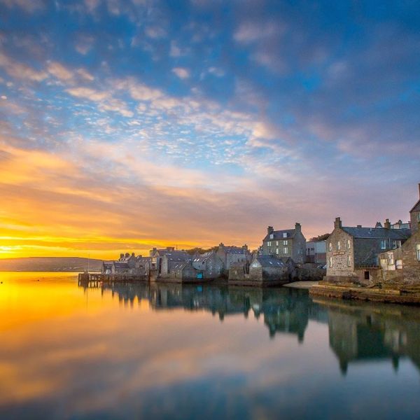 Lerwick's stone waterfront reflected in the sea at sunset