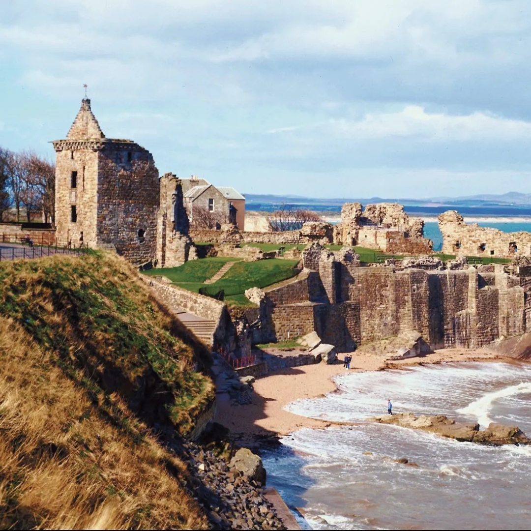 A scenic view of St. Andrews in Scotland, showing historic stone buildings and a coastline.